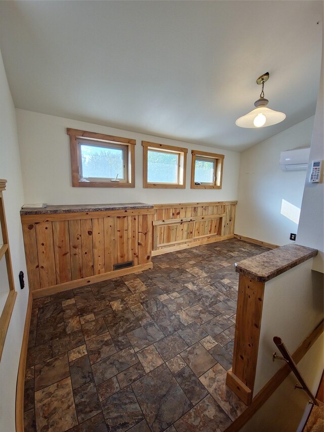 512 S Oak St, Townsend, MT 59644 - interior space featuring a wall mounted AC, baseboards, stone finish floor, and visible vents