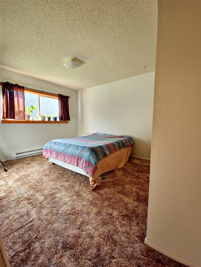 bedroom featuring a textured ceiling, carpet flooring, and a baseboard heating unit