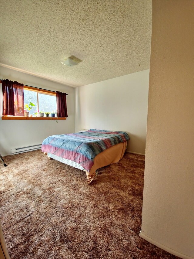 512 S Oak St, Townsend, MT 59644 - bedroom with baseboard heating, carpet floors, a textured ceiling, and baseboards