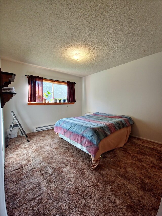 512 S Oak St, Townsend, MT 59644 - bedroom with carpet, a textured ceiling, and a baseboard radiator
