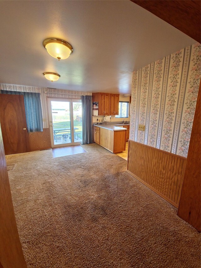 512 S Oak St, Townsend, MT 59644 - kitchen with brown cabinets, light countertops, a wealth of natural light, and light colored carpet