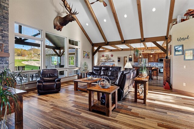 living room with high vaulted ceiling, ceiling fan, hardwood / wood-style floors, and beam ceiling