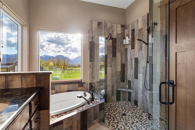 bathroom with independent shower and bath, vanity, and a mountain view