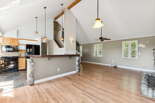 963 Colorado Ave, Whitefish, MT 59937 - kitchen with black appliances, dark countertops, a ceiling fan, open floor plan, and hanging light fixtures