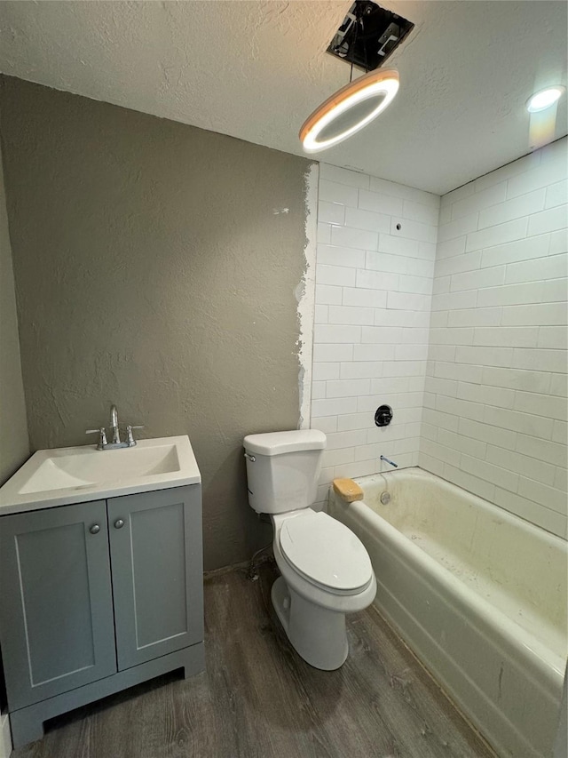 full bathroom with vanity, toilet, wood-type flooring, and a textured ceiling