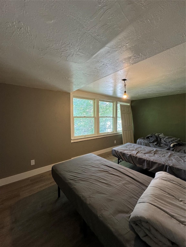 bedroom featuring hardwood / wood-style floors and a textured ceiling