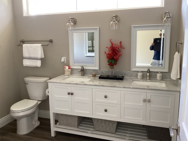 bathroom with a wealth of natural light, wood-type flooring, toilet, and dual bowl vanity