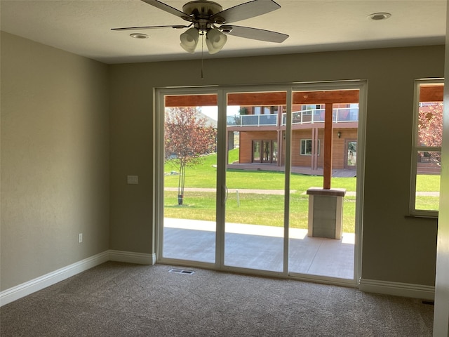 doorway featuring carpet floors and ceiling fan