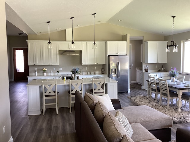 kitchen with an island with sink, dark hardwood / wood-style flooring, white cabinets, and stainless steel refrigerator with ice dispenser