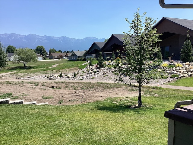 view of home's community with a mountain view and a lawn