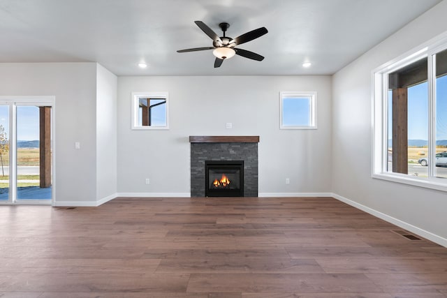 unfurnished living room featuring a wealth of natural light and dark hardwood / wood-style flooring