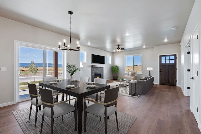 dining space with wood-type flooring and ceiling fan with notable chandelier