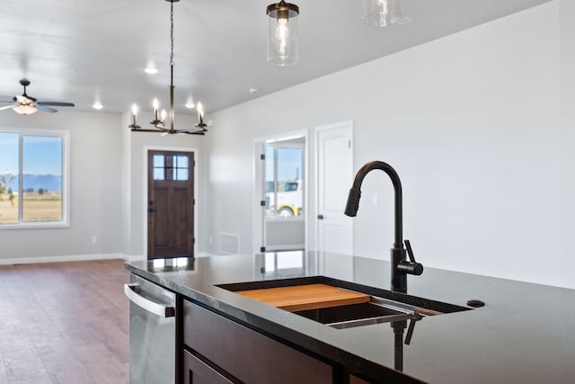 kitchen featuring a notable chandelier, hardwood / wood-style flooring, decorative light fixtures, and sink