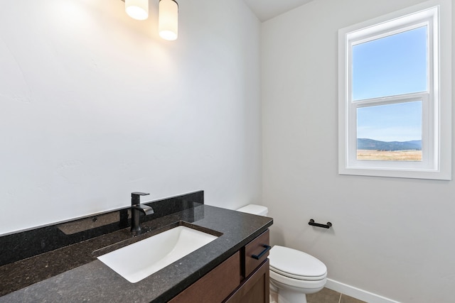 bathroom with a healthy amount of sunlight, tile patterned flooring, vanity, and toilet