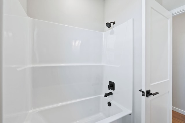 bathroom featuring hardwood / wood-style floors and bathtub / shower combination