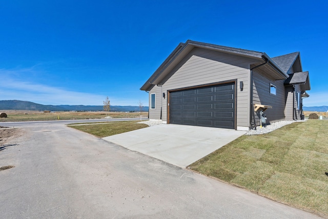 exterior space featuring a mountain view and a lawn