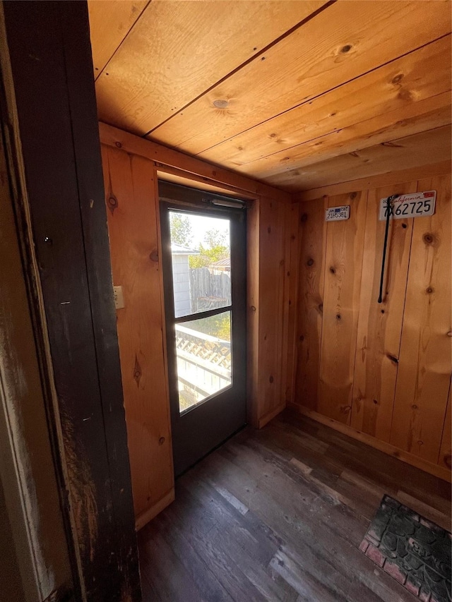 entryway with dark hardwood / wood-style flooring, wood ceiling, and wooden walls