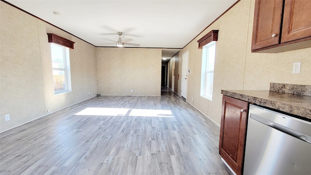 unfurnished living room with light wood-type flooring, a wealth of natural light, and crown molding