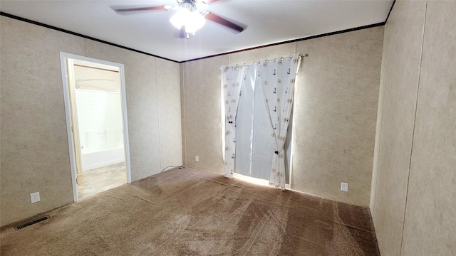 carpeted empty room with ornamental molding and ceiling fan