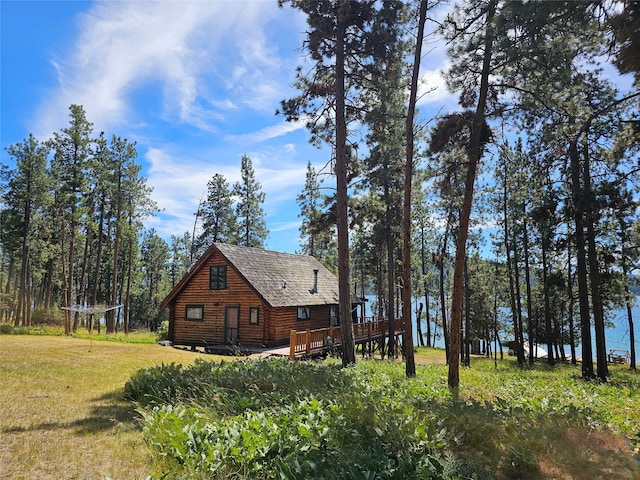 view of side of property with a trampoline, a deck, and a lawn