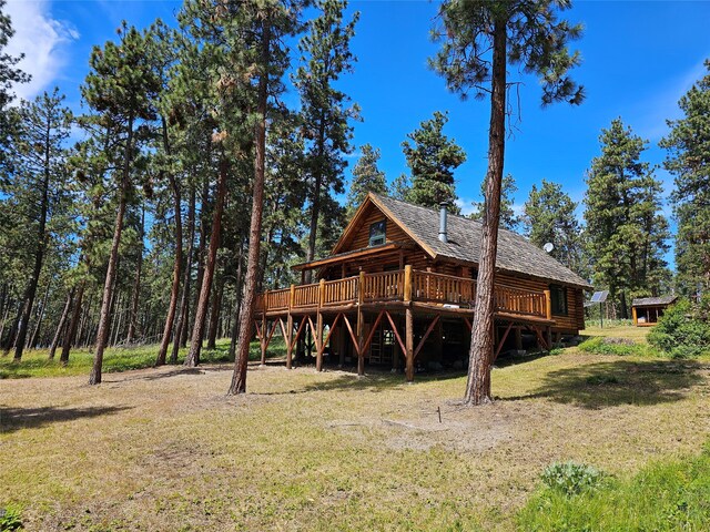 back of property featuring a yard and a wooden deck