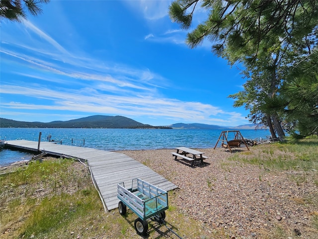 water view featuring a dock and a mountain view