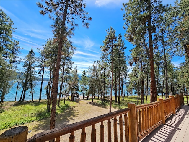 deck with a water view and a yard