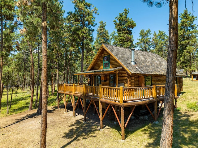 back of house with a deck and a yard