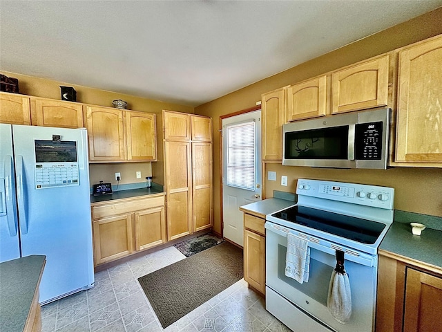 kitchen featuring light brown cabinetry, fridge with ice dispenser, stainless steel microwave, and white range with electric stovetop