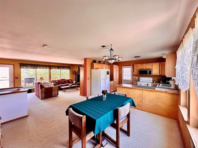 dining space with an inviting chandelier and light colored carpet