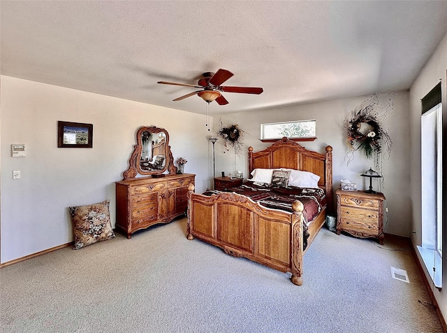 bedroom featuring a textured ceiling, ceiling fan, visible vents, and light colored carpet