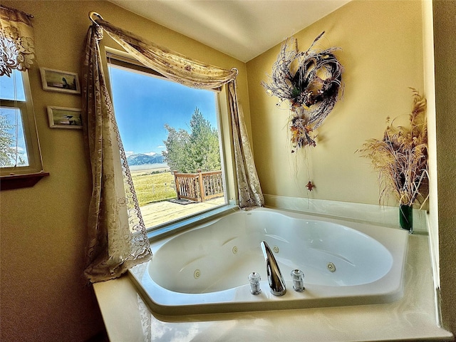 full bathroom featuring plenty of natural light and a tub with jets