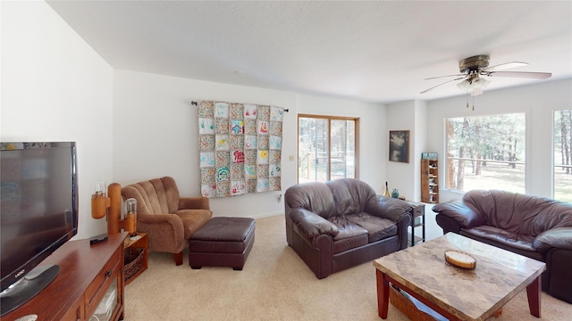 living area featuring light carpet, a wealth of natural light, and ceiling fan