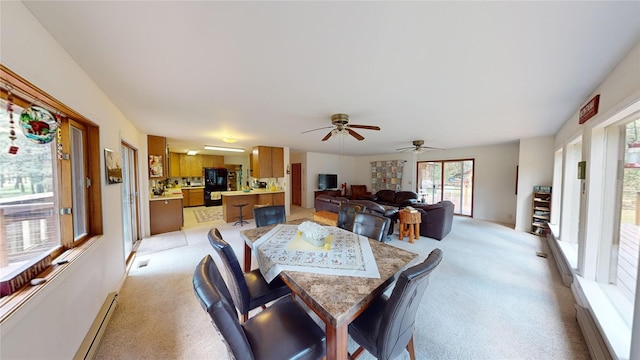 dining room featuring baseboard heating, light carpet, ceiling fan, and visible vents