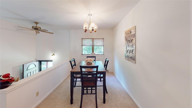 carpeted dining room featuring baseboards and ceiling fan with notable chandelier