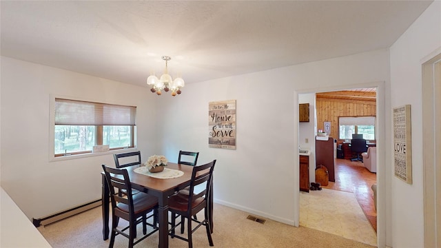 dining area featuring a baseboard radiator, an inviting chandelier, baseboards, and visible vents