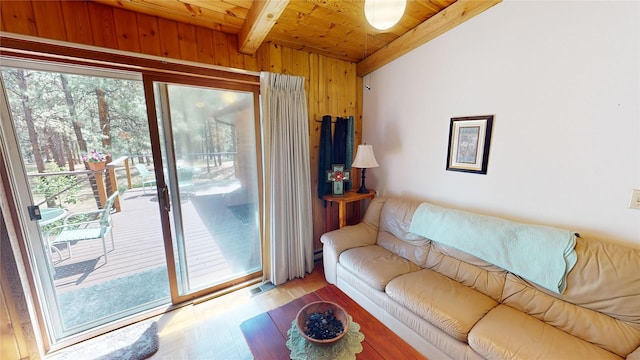 living room with lofted ceiling with beams, visible vents, wood ceiling, wood finished floors, and wood walls