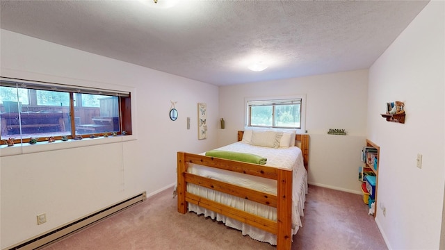 bedroom featuring light carpet, a baseboard heating unit, baseboards, and a textured ceiling