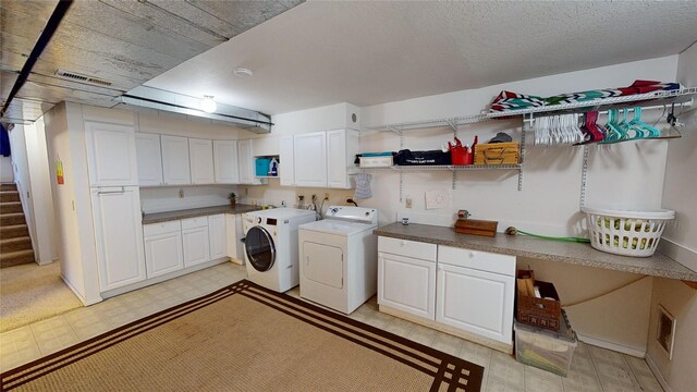 laundry area featuring cabinet space, visible vents, independent washer and dryer, and light floors