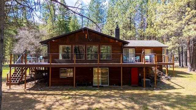 rear view of property featuring stairs, cooling unit, a chimney, and a wooden deck