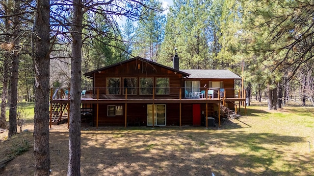 rear view of house featuring a chimney, a lawn, a deck, and stairway