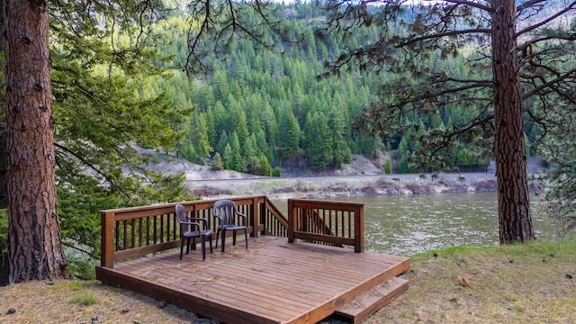 wooden terrace with a water view and a wooded view