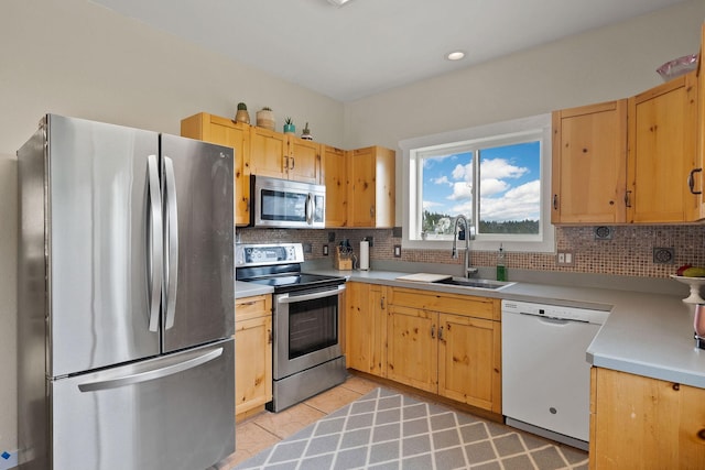 kitchen with stainless steel appliances, light tile patterned flooring, sink, and backsplash