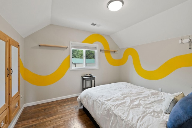 bedroom with vaulted ceiling and dark hardwood / wood-style floors