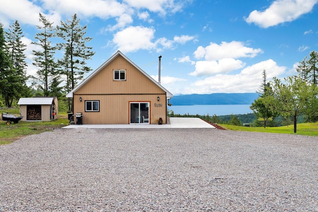 back of house with a mountain view and a storage shed