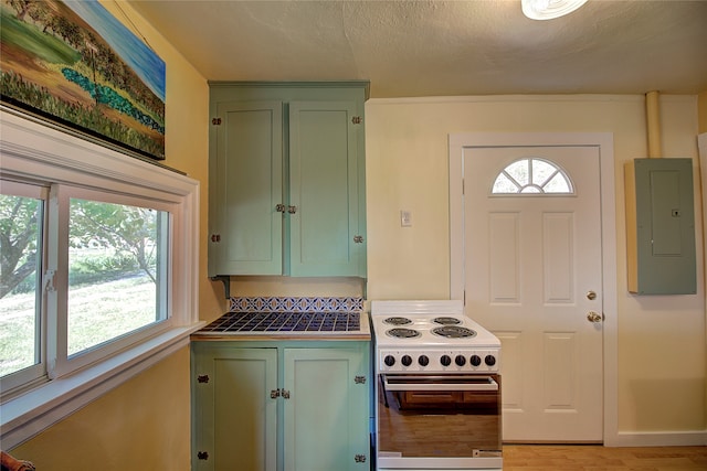 kitchen with a healthy amount of sunlight, green cabinetry, and range with electric cooktop