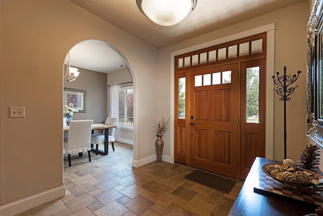 tiled foyer with plenty of natural light and a chandelier