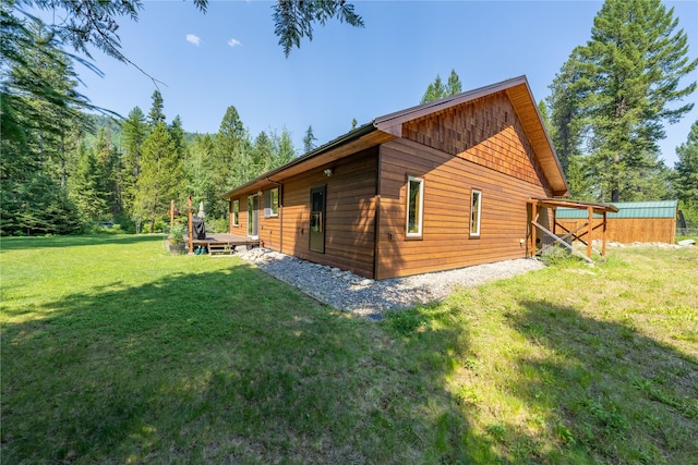 view of side of property with a yard and a deck