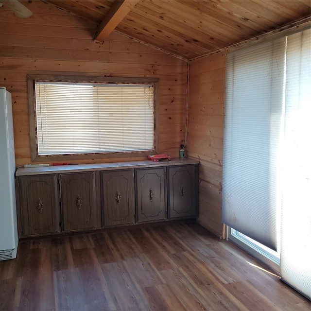 interior space with lofted ceiling with beams, wooden walls, wood ceiling, and dark wood-style flooring