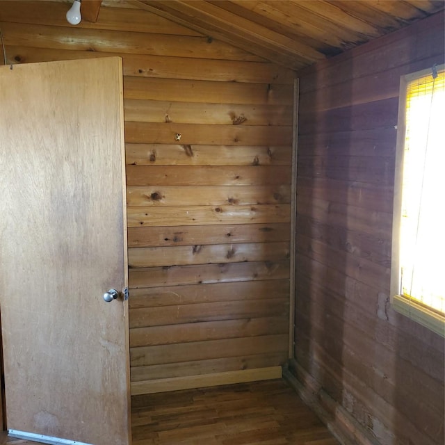 spare room with wooden walls, vaulted ceiling, dark wood-style floors, and wooden ceiling
